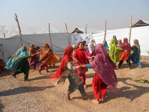 Pakistan, young girls in colorfoul traditional outfits, holding hands and dancing in circles