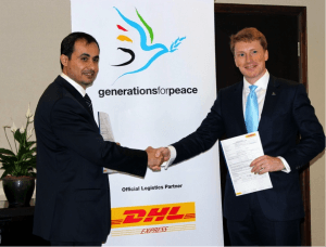 Generations For Peace CEO Mark Clark shaking hands with DHL representative