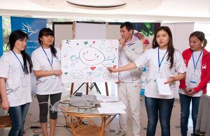 Kyrgyzstan, volunteers gathered around their artwork representing smiley faces