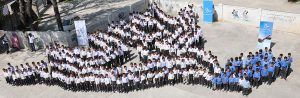 Bird's-eye view of Jordanian school children grouped in the shape of a dove as Generations For Peace's logo
