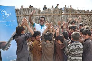 Pakistan, young boys cheering with a Generations For Peace volunteer
