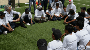 children sitting in a circle listening to a volunteer